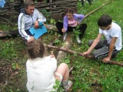 Дети пилят дрова в походе